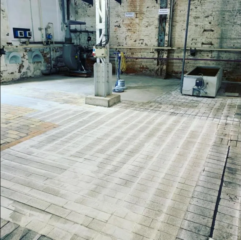 Sanierter Industriehallenboden mit Epoxidharz-Beschichtung, im Hintergrund Anlagentechnik